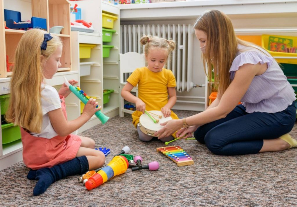 female occupational therapist having kids play with instruments
